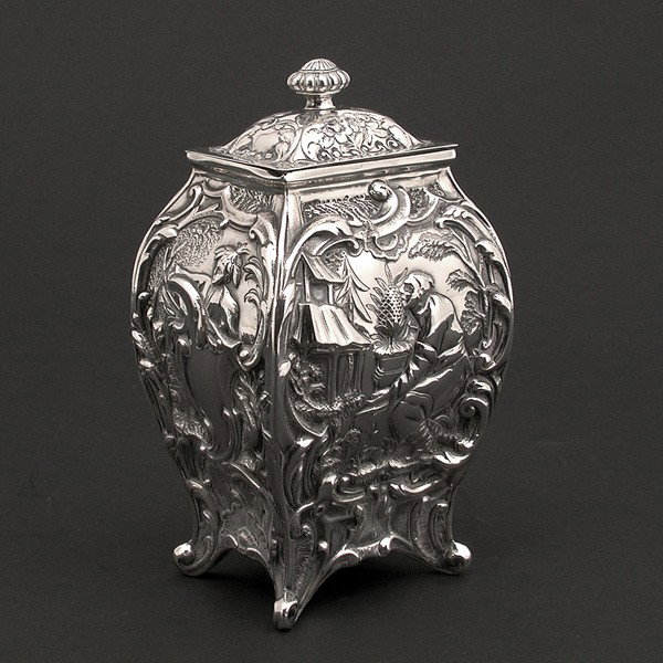 Sterling Silver English Style Tea Caddy: TEA CADDY. Sterling silver English style tea caddy with floral decoration on lid and body, depicting Asian and Indian scenes in relief. 5.75" h, 5.91 ozt., in very good condition.