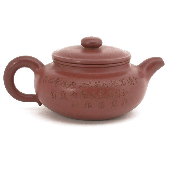 Chinese Clay Teapot: TEAPOT. Chinese browned clay teapot with Chinese characters on both sides, signed at base. 3" h x 7" w x 4.75" d.