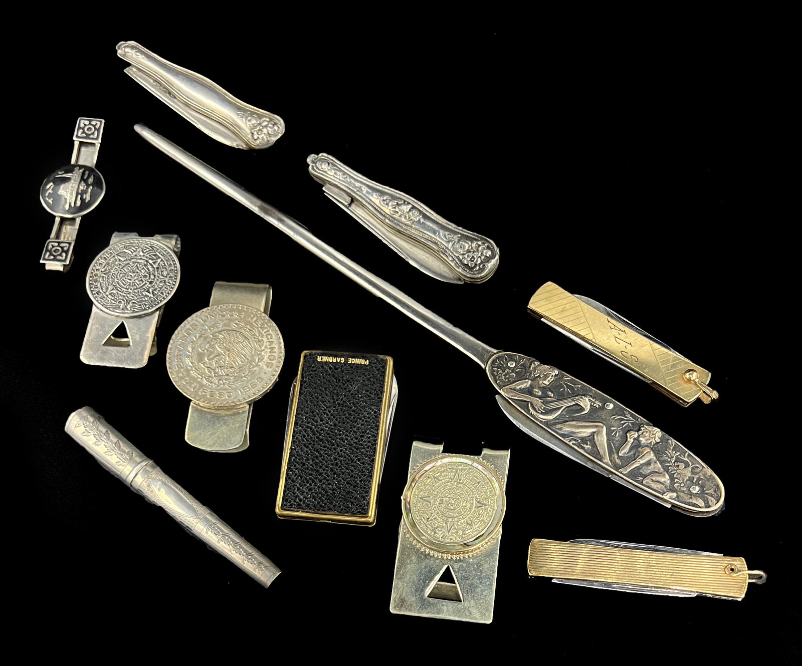 Money Clips, Pocket Knives, Needle Case, Letter Opener: Grouping of Money Clips (3 with coins), Pocket Knives, Needle Case, Letter Opener. Some marked sterling. Longest 9".