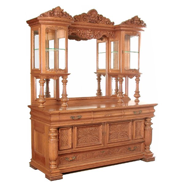 American Oak Cabinet Top Sideboard, 19th century: SIDEBOARD. American oak 19th century sideboard, the Northwind and shell carving, beveled glass cabinet, and mirrored back supported by reeded and carved columns above a carved cupboard, drawer, and co
