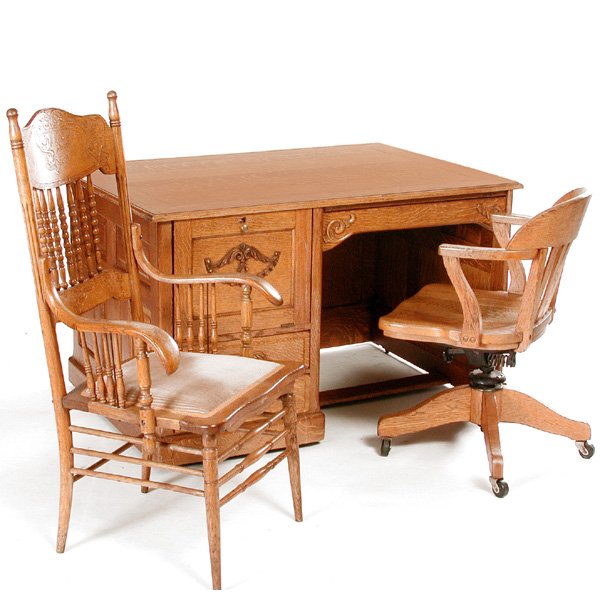 American Oak Flat Top Desk and Chairs, 19th c: DESK. American oak 19th century single pedestal flat top desk with typewriter (computer?) compartment and fancy applique carving. Accompanying this desk is an oak swivel desk chair and a pressback arm