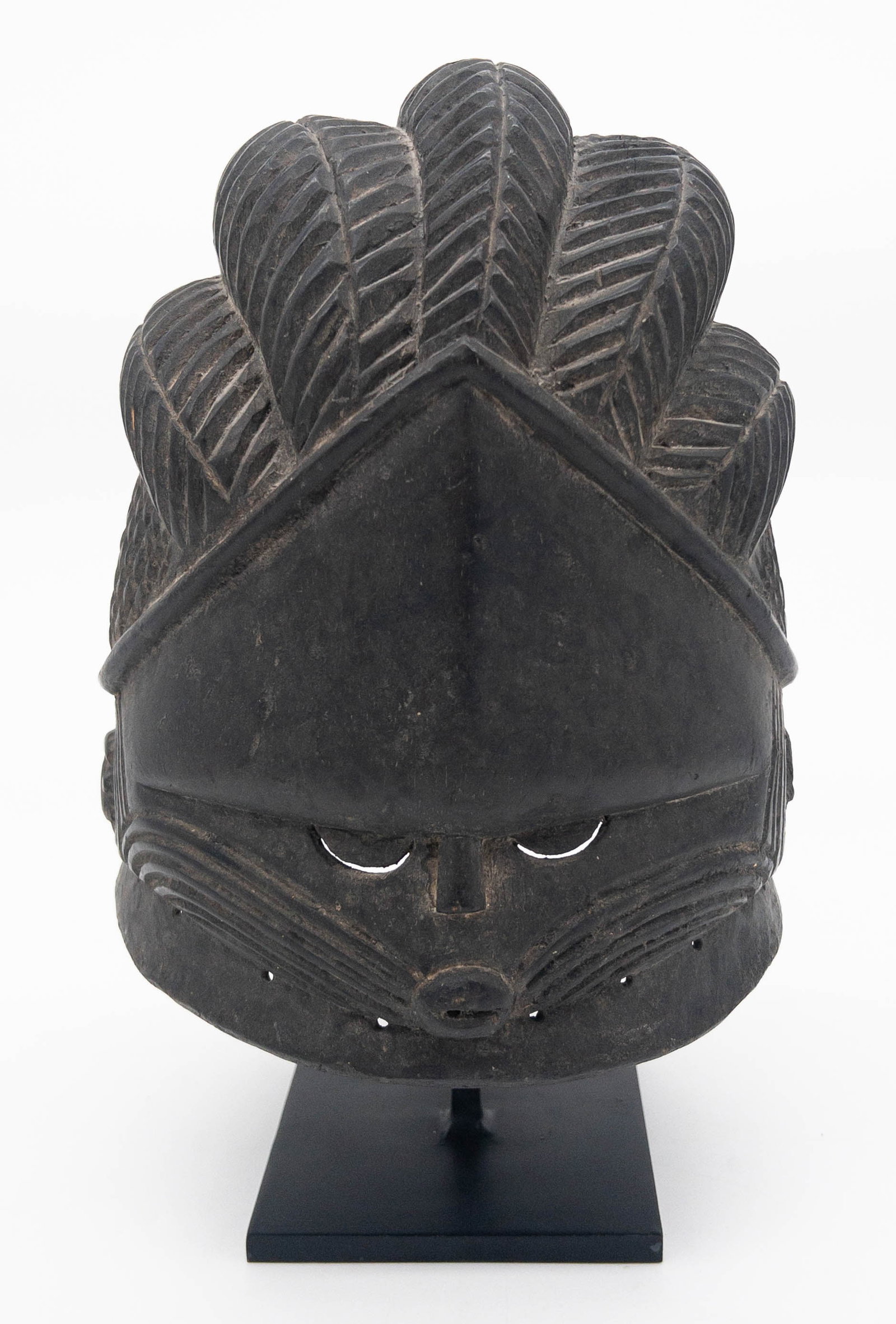 Mende Bundu Wood Mask, Sierra Leone: Mende Bundu Wood Mask. This mask is an altar piece in a bird-like form on a post, featuring a head with a clearly articulated face and piercing eyes. The body lacks details, except for two pigmented v