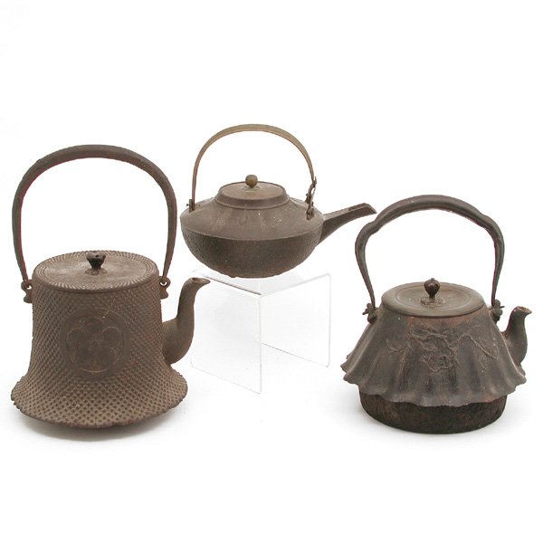 Lot of 3 Japanese Iron Teapots: TEAPOTS. Lot of 3 Japanese iron teapots to include: one with embossed dots and floral medallion, signed, 10.5" h with handle; one with branch motif and fluted edge, 9" h with handle; one with feather 