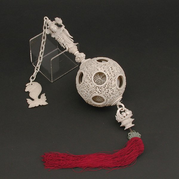 Chinese carved wedding ball.: CARVING. Chinese carved wedding ball. The intricately carved ball with 7 additional balls within suspended on a carved chain and female figure ending in a flower basket, 20" without tassel x 4" ball d