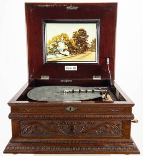 Olympia Music Box #103 w/ 13 Discs: Olympia music box #103, circa 1900. Mahogany case fitted with a printed lake scene. Mechanism numbered "12386". Thirteen music discs included (each 14" diameter). Measures appx 11" tall x 20 1/2"