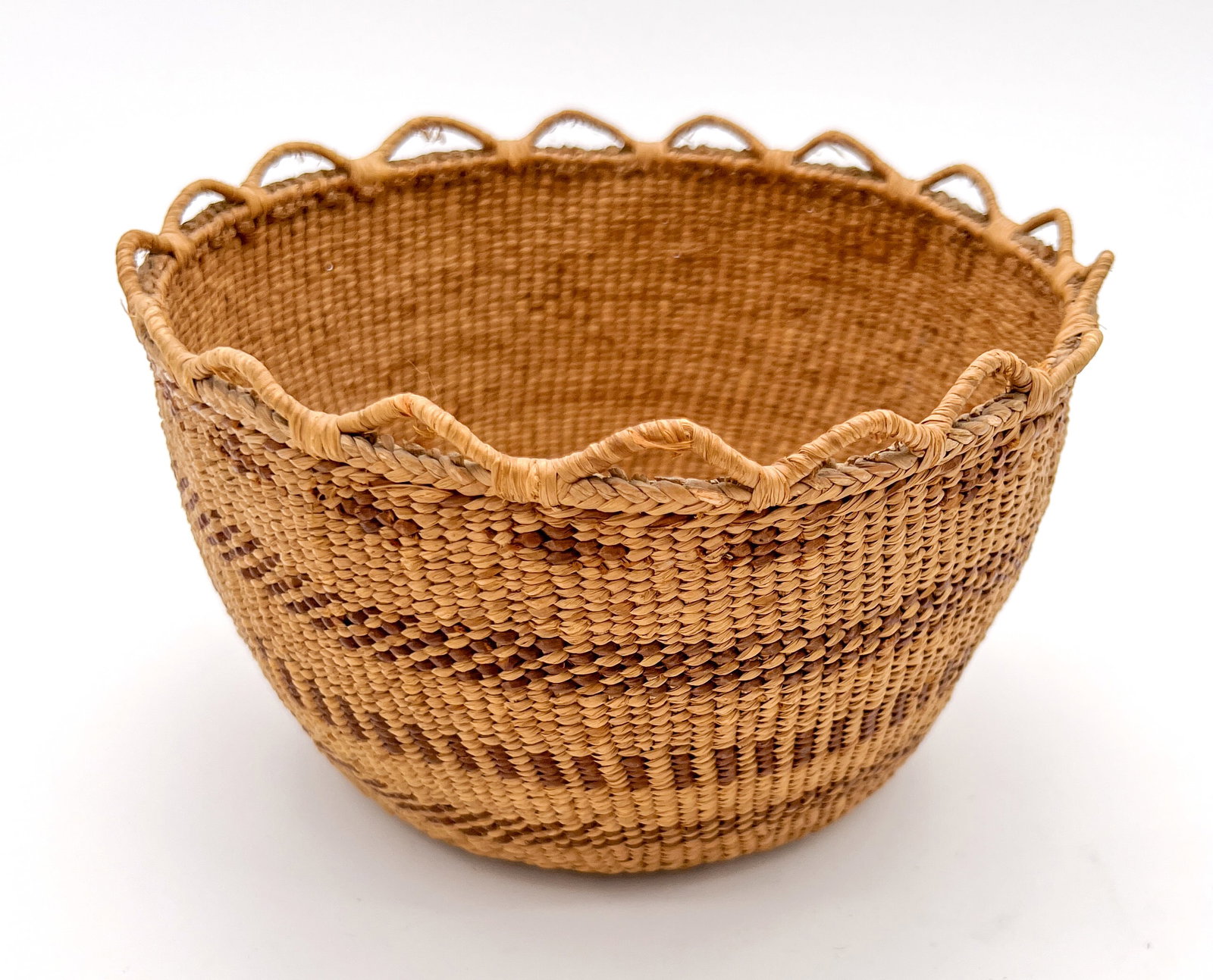 Native American Skokomish basket: Native American Skokomish basket. Weaver attributed to Hely Diver with loop rim and band design. 4 1/2"t x 8"w x 7"d. Good condition.