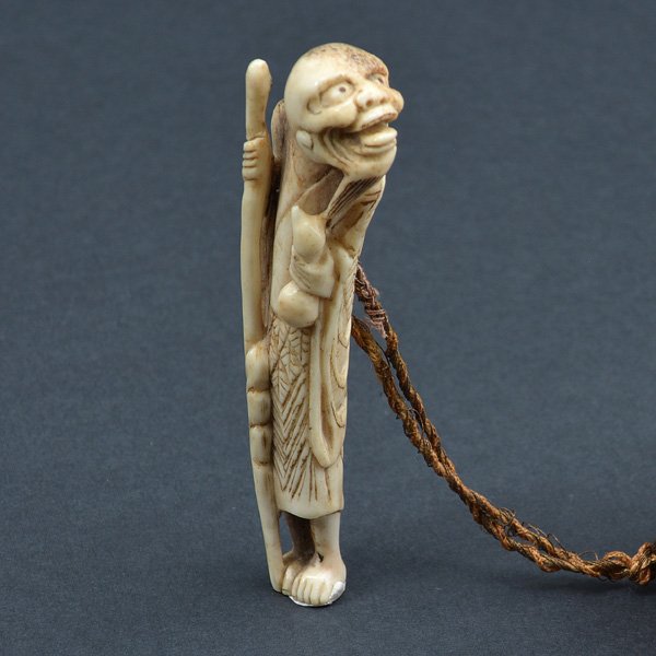 Ivory Netsuke with Tassel: Ivory Netsuke of a wiseman holding a staff, 4" x 1 1/4".