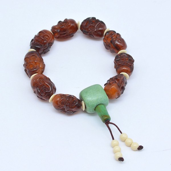 Chinese Carved Amber Buddhist Prayer Beads: Chinese carved amber Buddhist prayer beads, comprising of 9 translucent beads each carved as two heads of Luohan, 9" long.