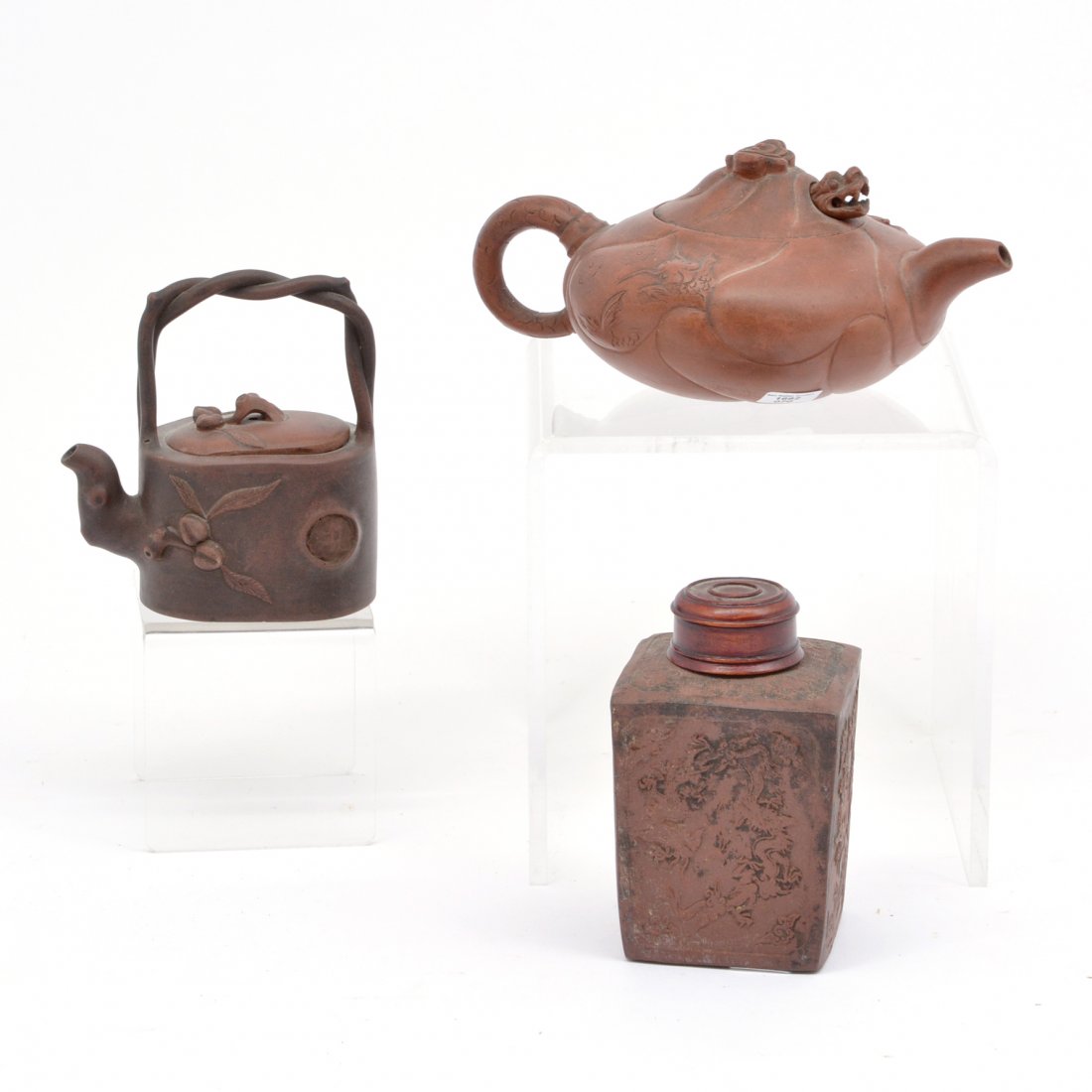 2 Teapots and One Container: Lot of three Asian items: teapot with articulated dragon; small teapot with "branch handle" and early dragon embossed tea container. Marks at bottom, 2 with export seals. Tallest 4.5"; Widest 7.5".