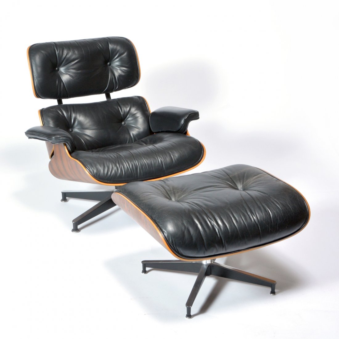 Charles and Ray Eames Lounge Chair and Ottoman: Charles and Ray Eames lounge chair and ottoman, rosewood and black leather upholstery on enameled aluminum and rubber multi-leg base, label at bottom "Herman Miller", chair: 32" h x 33" w x 34" d, ott