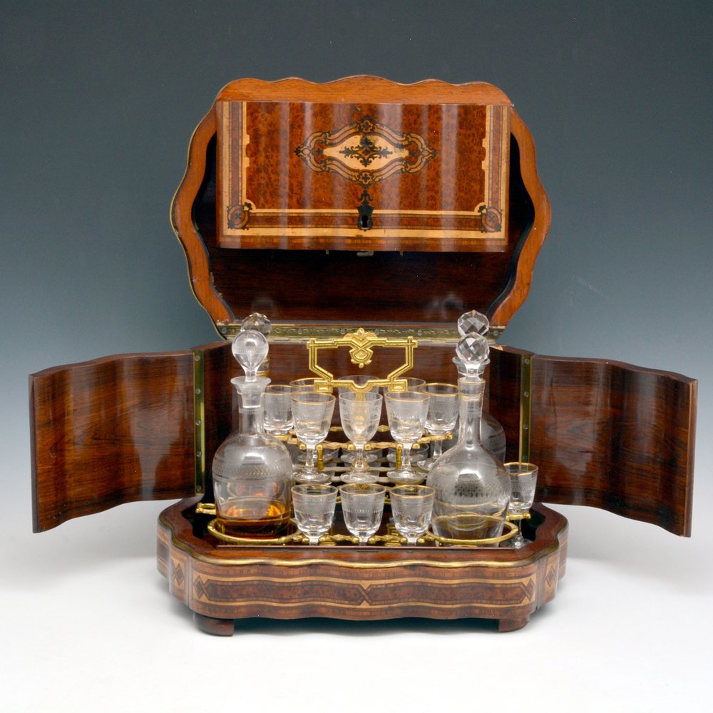 French Inlaid Wood Case & Crystal Tantalus: French Inlaid Tantalus, the shaped case with multi-wood inlay and bronze banding opens to reveal a gilded, removable carrier complete with bottles and glasses (1 missing), 11"h x 15"w x 11"d, very goo
