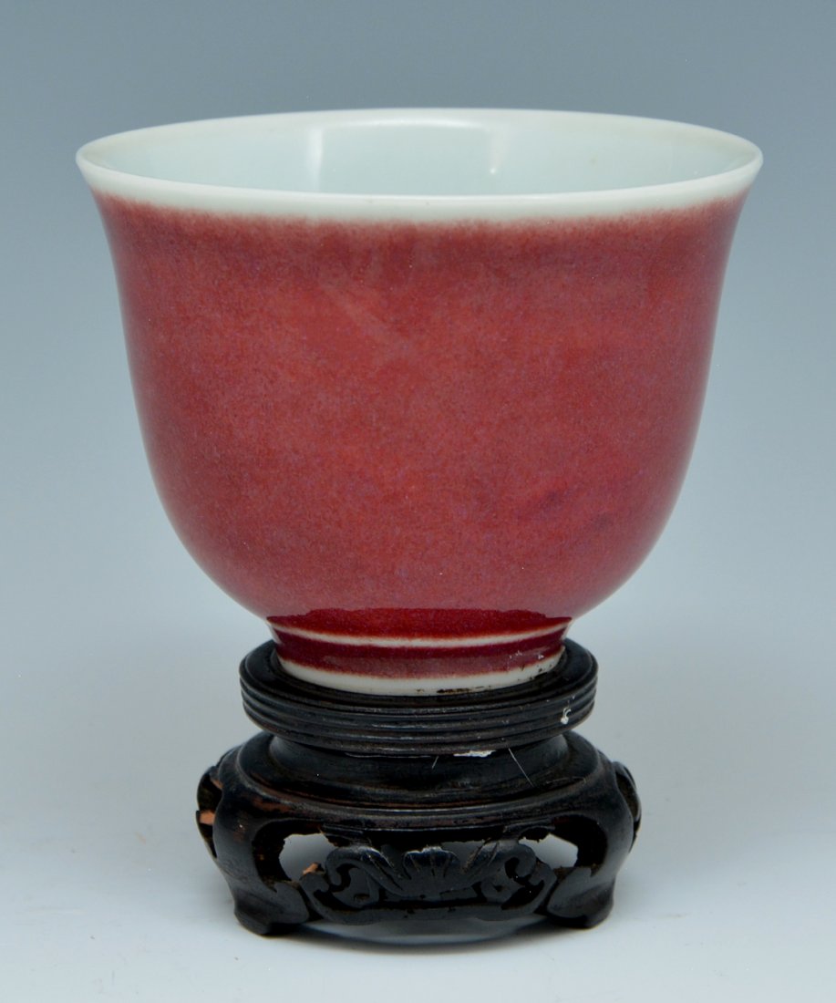 Ox blood glazed wine cup: Ox blood glazed wine cup covered with rich mottled red glaze, base inscribed with mark, fitted with hardwood stand, 2 3/4"h.