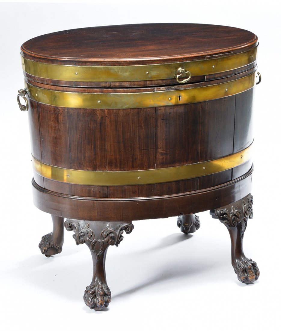 English 19th c Mahogany Oval Cellaret: English 19th c mahogany oval cellaret, tin lined with fitted interior, brass bound supported by carved claw and ball feet. 25 1/2"h x 27"w x 19"d. Very good condition.