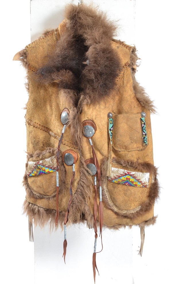 Buffalo Hide High Plains Indian Vest w/Beadwork: High Plains Indian Buffalo hide vest, fur inside, four metal conchos, beadwork on three pockets, two pockets decorated with snake skin, beadwork medallions on front shoulders and center back. Appx 32"