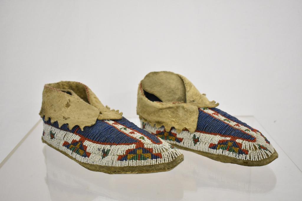 Northern Plains Native American Beaded Moccasins: Early 1900's female moccasins. brown, green, blue, red and white beads. Measures 9 1/2". Condition very good. Dr. Michael O'Banion Estate.