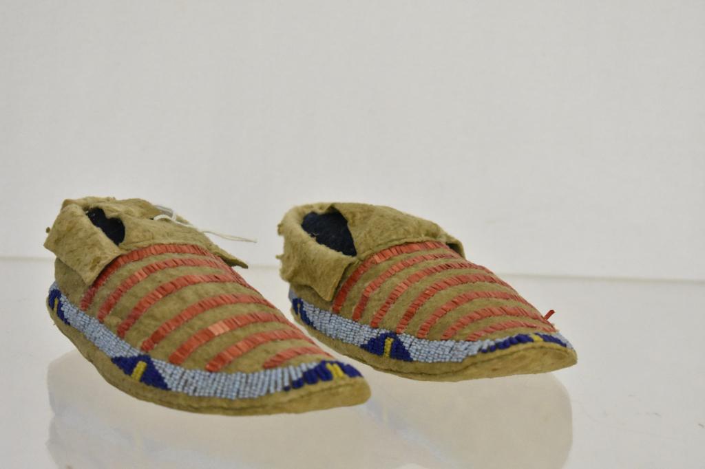 Northern Plains Native American Quill Moccasins: Early 1900's child's moccasins. Quills are a copper colored, beads are dark blue, light blue and yellow. Measures 6 3/4". Condition very good. Dr. Michael O'Banion Estate.