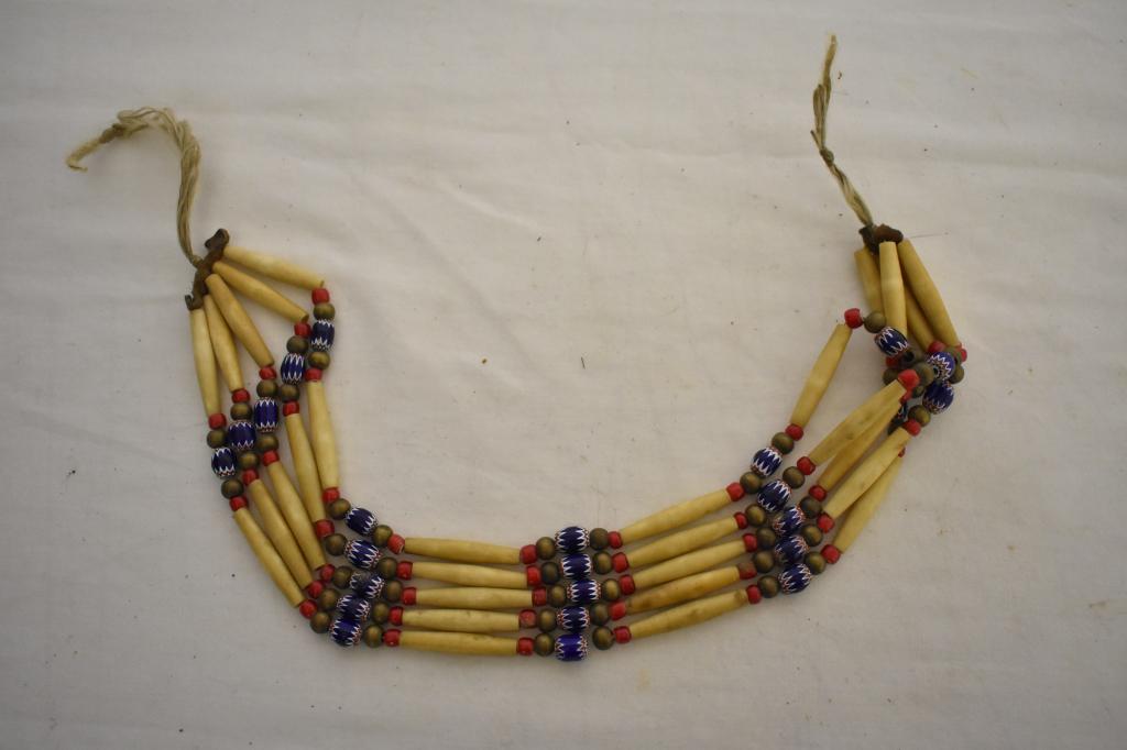 Native American Beaded Buffalo Bone Necklace: Five strands and is 16 1/2" long. Leather ends holding strands. Brown and red beads along with decorative blue, red and white beads. Dr. Michael O'Banion Estate.