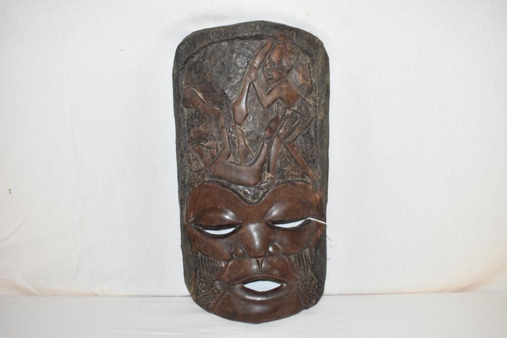 African Carved Wooden Mask: Nice details. Features 2 warriors fighting, one man is on his back holding a club the other is holding spear. 18" x 9". Dr. Michael O'Banion Estate.