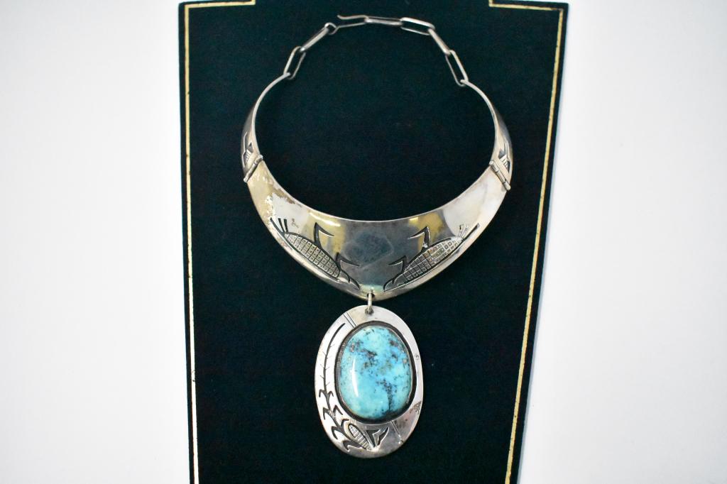 Turquoise & Sterling Corn Choker Necklace. Signed: Pendant is 2 1/2” x 2” with a corn stalk and corn cob design. Collar is also decorated with corn motif. Approximately 15”. Signed of back of pendant. See photos. We tested the silver and it test