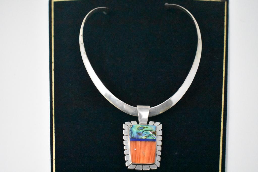 Abalone, Lapis Lazuli & Orange Necklace. Signed: Pendant is has 3 kinds of stones: abalone, a thin stripe of lapis lazuli, then a striped orange. The orange stone could be spiny oyster. Signed with what appears to be a reversed “R” and “D” o