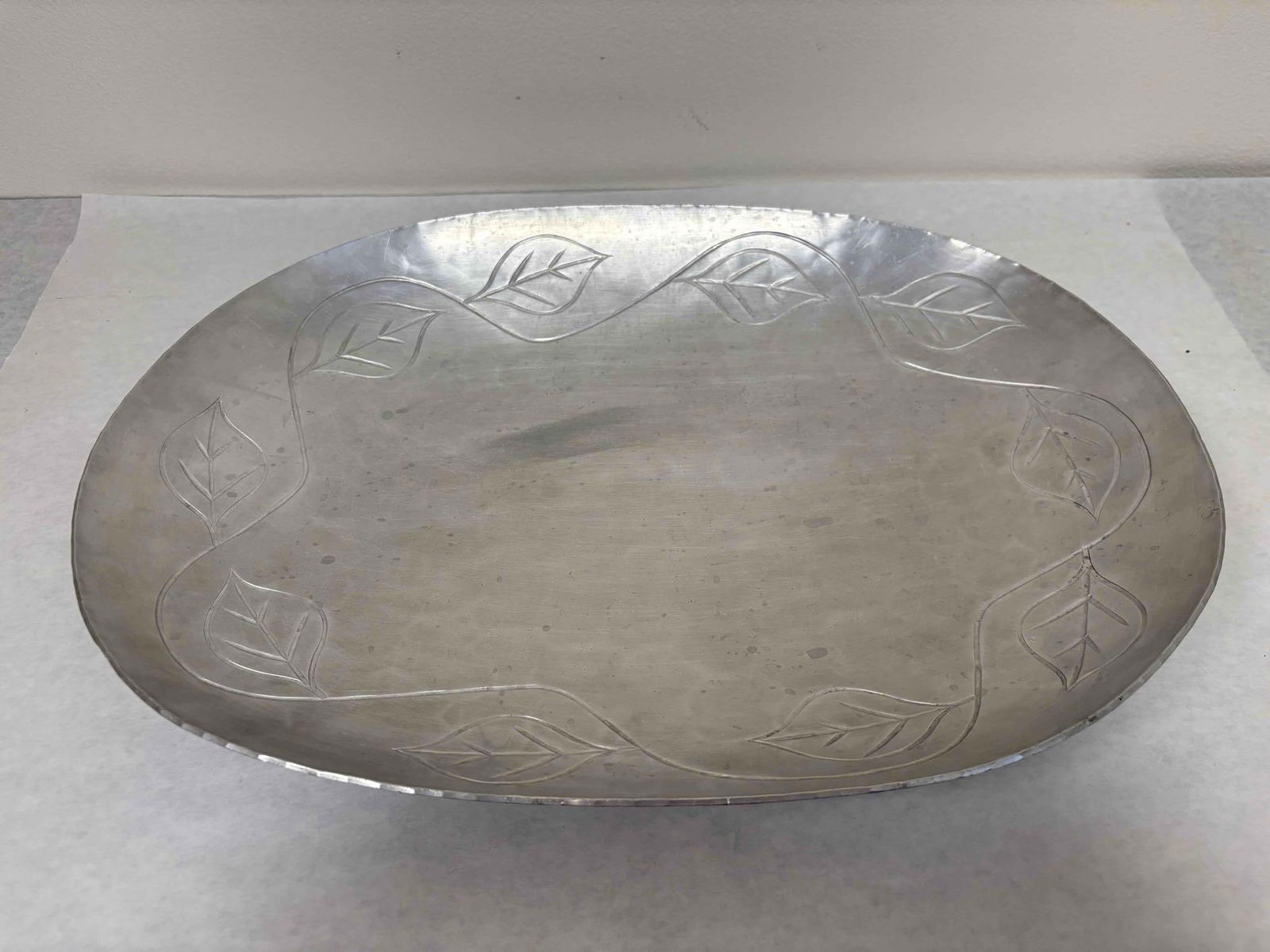 Palmer Smith Hammered Aluminum Serving Dish: This stunning serving tray by Palmer Smith features a beautiful leaf motif that is sure to add a touch of elegance to any space. Crafted from high-quality aluminum, this item is both durable and