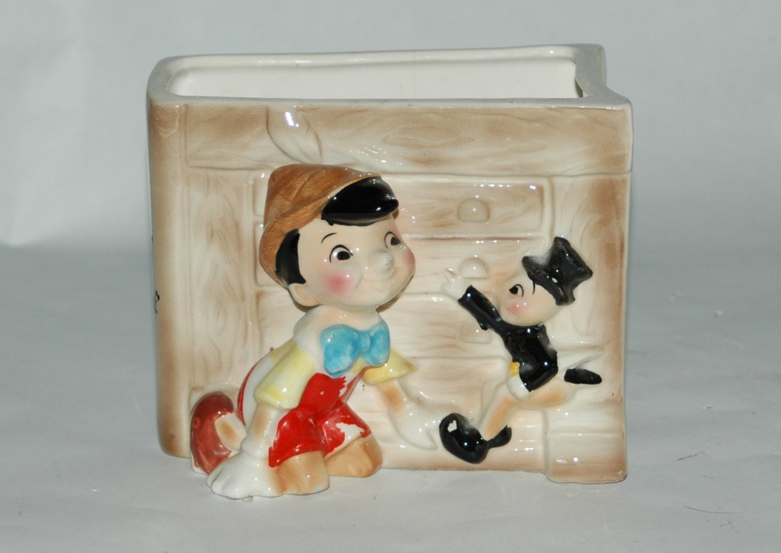 Ceramic Walt Disney Productions Pinocchio Book Planter: Marked Walt Disney Production,s Pinocchio & Jiminy Cricket ceramic planter or pencil holder. Shaped like a book. 5" length, 2-1/2" wide, 4" tall.