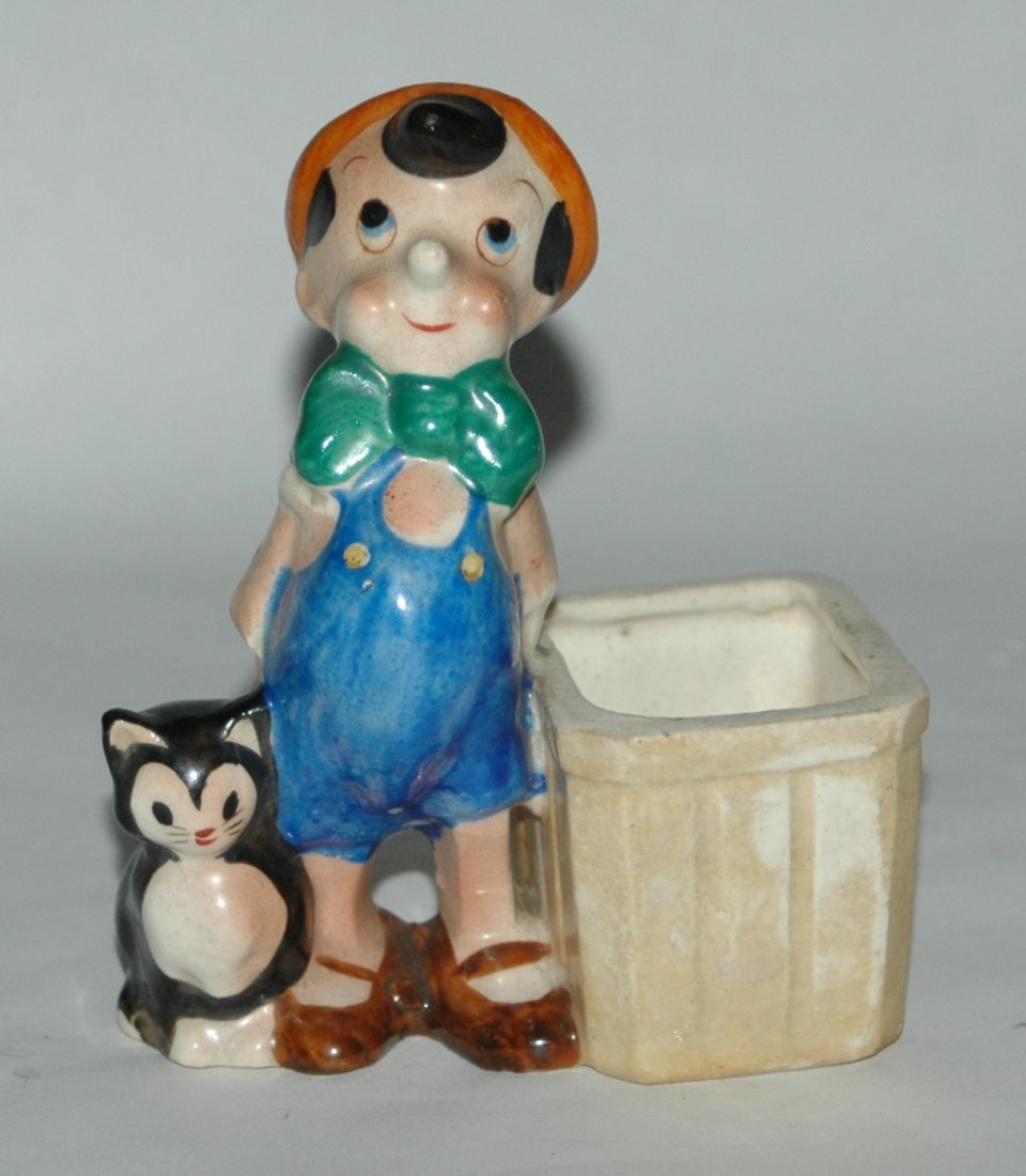 WDP Disney Pinocchio Ceramic Desk Top Holder: Ceramic Walt Disney Productions Pinocchio and Figaro the Cat Desk top toothpick or paperclip holder. 3-1/2" in length, 2" wide, 4-1/2" tall. Excellent condition.