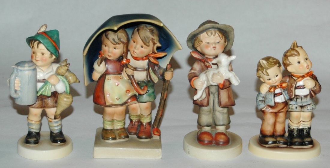 Group of four Hummel figures: Group of four Hummel figures. 1) Boy holds beer stein. 5 1/2". Large Bee mark. Mint. 2) Boy and girl under umbrella 6 1/4". Large Bee mark. Mint. 3) Boy holds lamb 6". Large Bee mark. Mint. 4) Max and