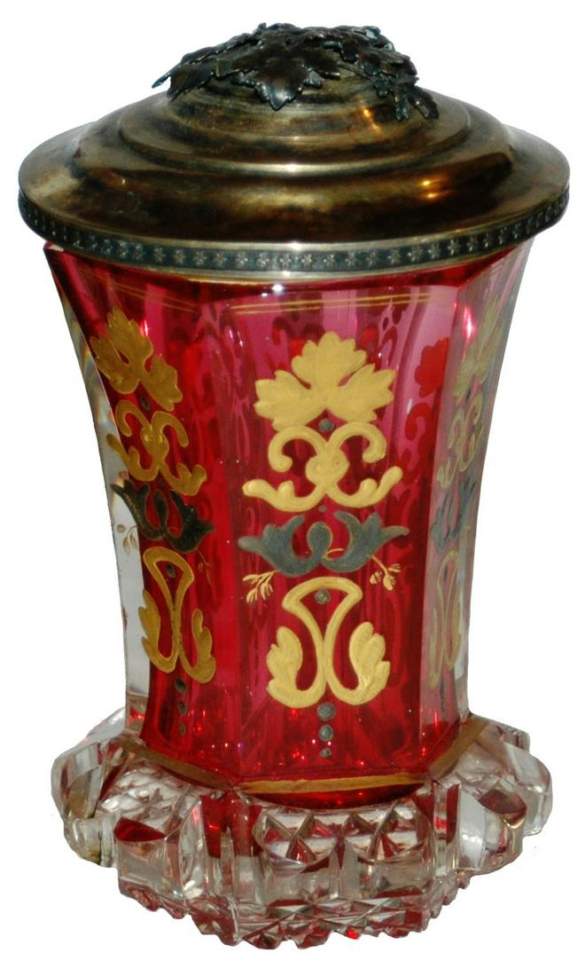 Faceted Glass Overlay Beaker Gilded Silver c1850: Blown Glass Overlay 5 1/4” Beaker. Clear over cranberry. Gilded and silvered pasty enamel on faceted body. Bohemian circa 1850. Gilded silver set on lid. Mint.