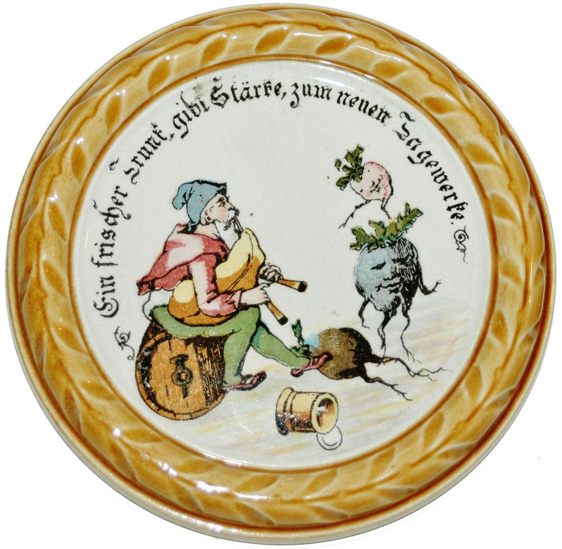 Mettlach Coaster Dwarf w Bagpipes & Radish: Mettlach #1032 PUG 5” Coaster. Dwarf plays bagpipes to radish. Mint.