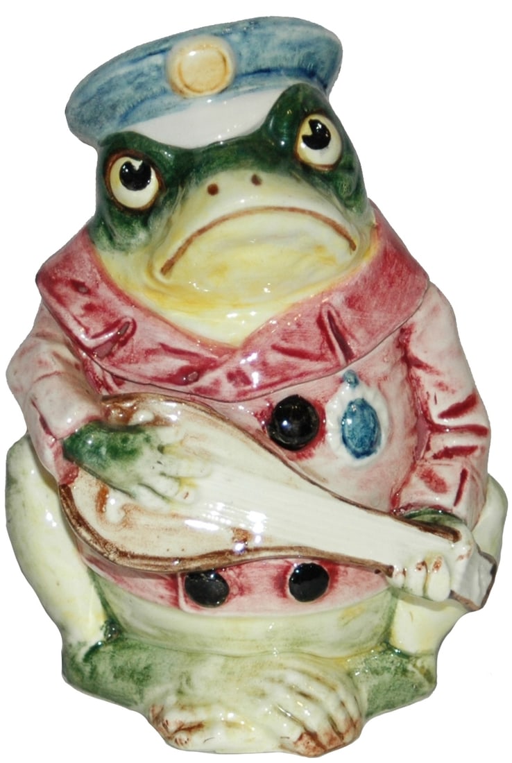 Majolica Student Frog Plays Mandolin Tobacco Jar: Austrian Majolica 7” Tobacco Jar. Student frog wears cap and plays mandolin Tiny glaze flake.