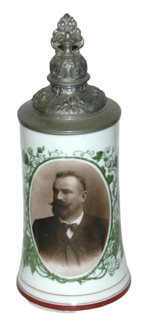Man w Brewery Items Photo Transfer Stein: Porcelain Photo Transfer 1/2L. Man with brewery implements and hops surround his photo. Fancy relief pewter lid. Litho. Mint.