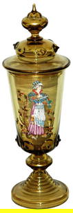 Enameled & Applied Amber Glass Pokal w Matched Lid: Blown Amber Glass 13 1/2” Pokal. Enameled woman fills goblet from large stein. Applied prunts on body and matching set on lid. Mint.