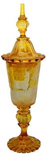 Impressive c.1875 Wheel-Cut Stag Glass Pokal: Blown Glass 20 ½” Pokal. Amber stained and intaglio wheel-cut stag in the forest scene. Bohemian circa 1875. Matching set on lid. Impressive. Mint.