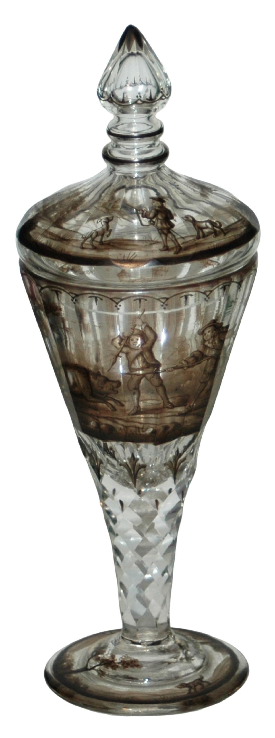 Glass Pokal w Boar Hunting Scene w Matching Lid: Blown Glass 9 1/2” Pokal. Black enamel scene of men hunting a boar on faceted body with matching lid. Diamond pattern cut stem.