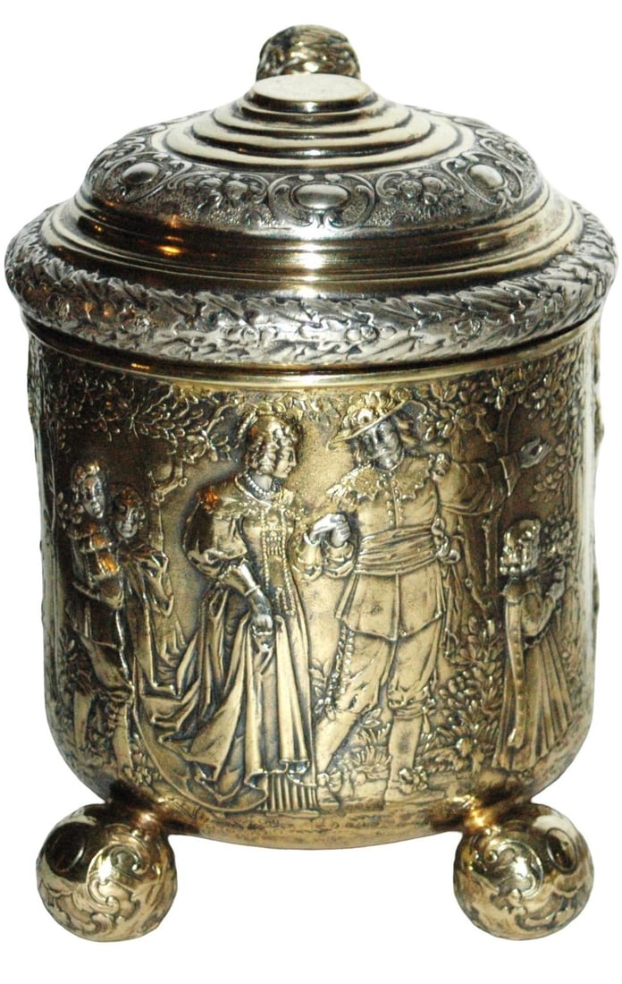 2L Detailed Scene 55oz Silver Stein w 4 Ball Feet: Partial Gild Relief Silver 2L. Detailed scenes of men carrying royal figure, Royal couple in front and three musicians. Four ball feet and matching ball thumblift. 55 oz. Hallmarks. Very good