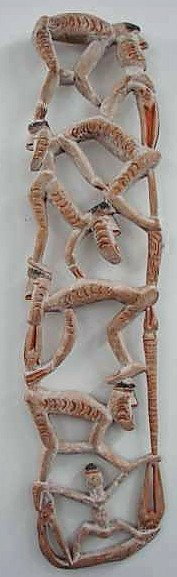 Oceanic Totem and Shield: 2 Oceanic Art items including: 1. Totem of striped, stacked, and crouched human figures. Painted and made of light wood. 43" height by 10" width. 2. Sheild with relief carvings. 27 1/2" height by 10 1