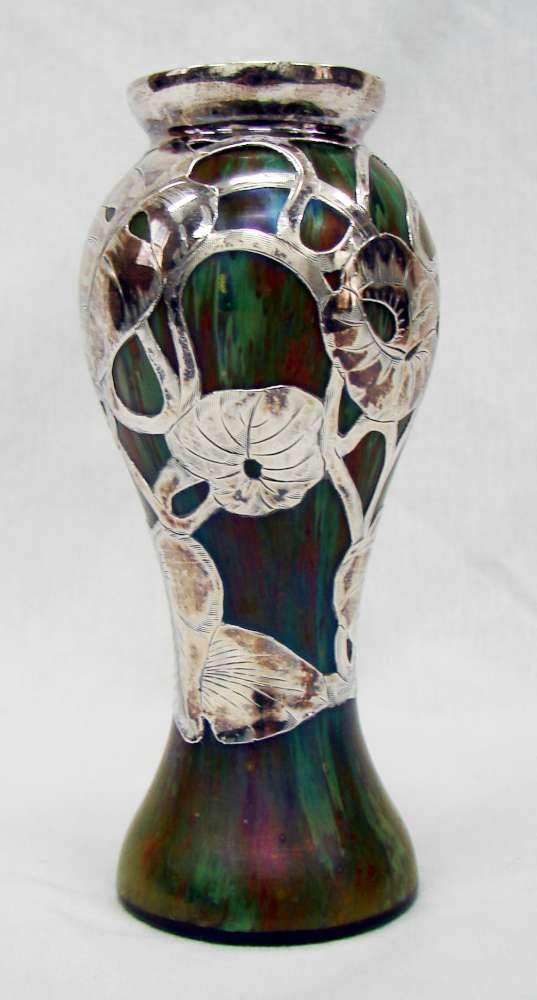 Sterling Silver Overlay Vase Loetz Phanomen Attribu: Green glass vase with sterling silver overlay and iridescent finish. The sterling is in a leafy philodendron pattern. The glass has spatters and striations. Probably Loetz phanomen. No markings. 6 1/2