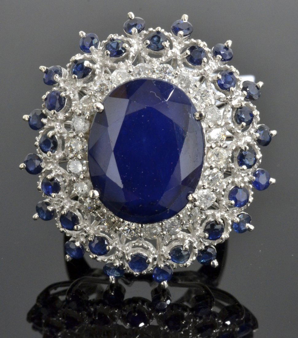 12.85 ct Sapphire & Diamond Ring AV: $5,845: 14K white gold ladies cast sapphire and diamond ring with 22 = 0.84 ct round brilliant cut diamonds and 12.85 ct of oval/round cut blue sapphires K25E18
