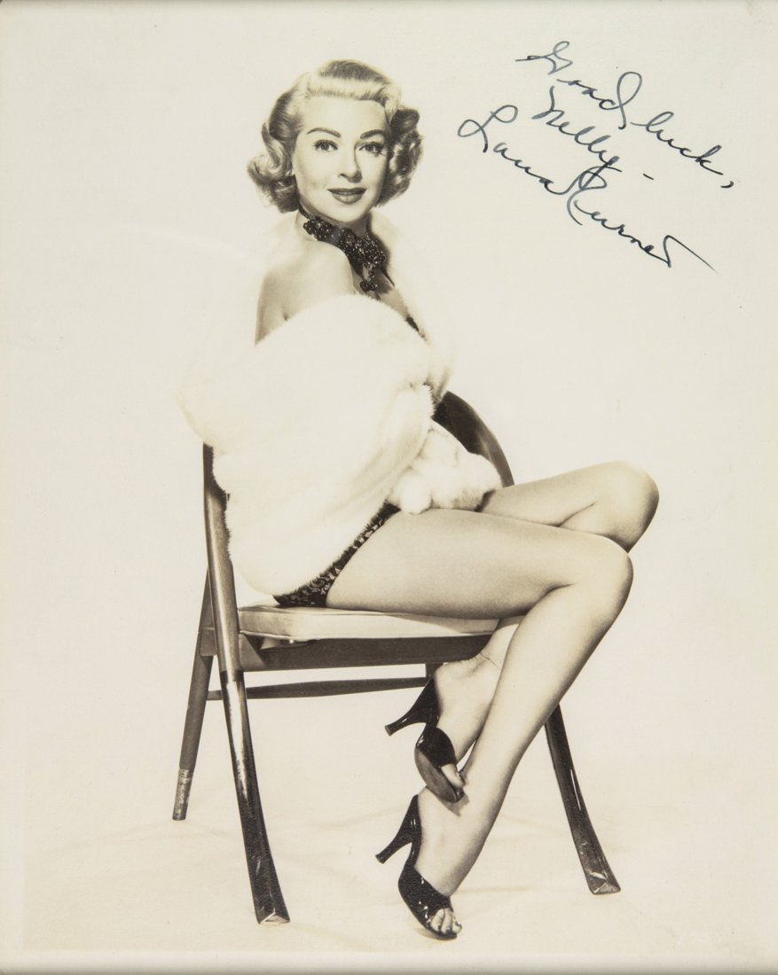 Turner Lana: Turner Lana. Ritratto fotografico con dedica autografa. Non datato. Dedica a pennarello nero: “Good luck, / Nelly / Lana Turner”. Ritratto a figura intera. In cornice bianca. Dimensioni de