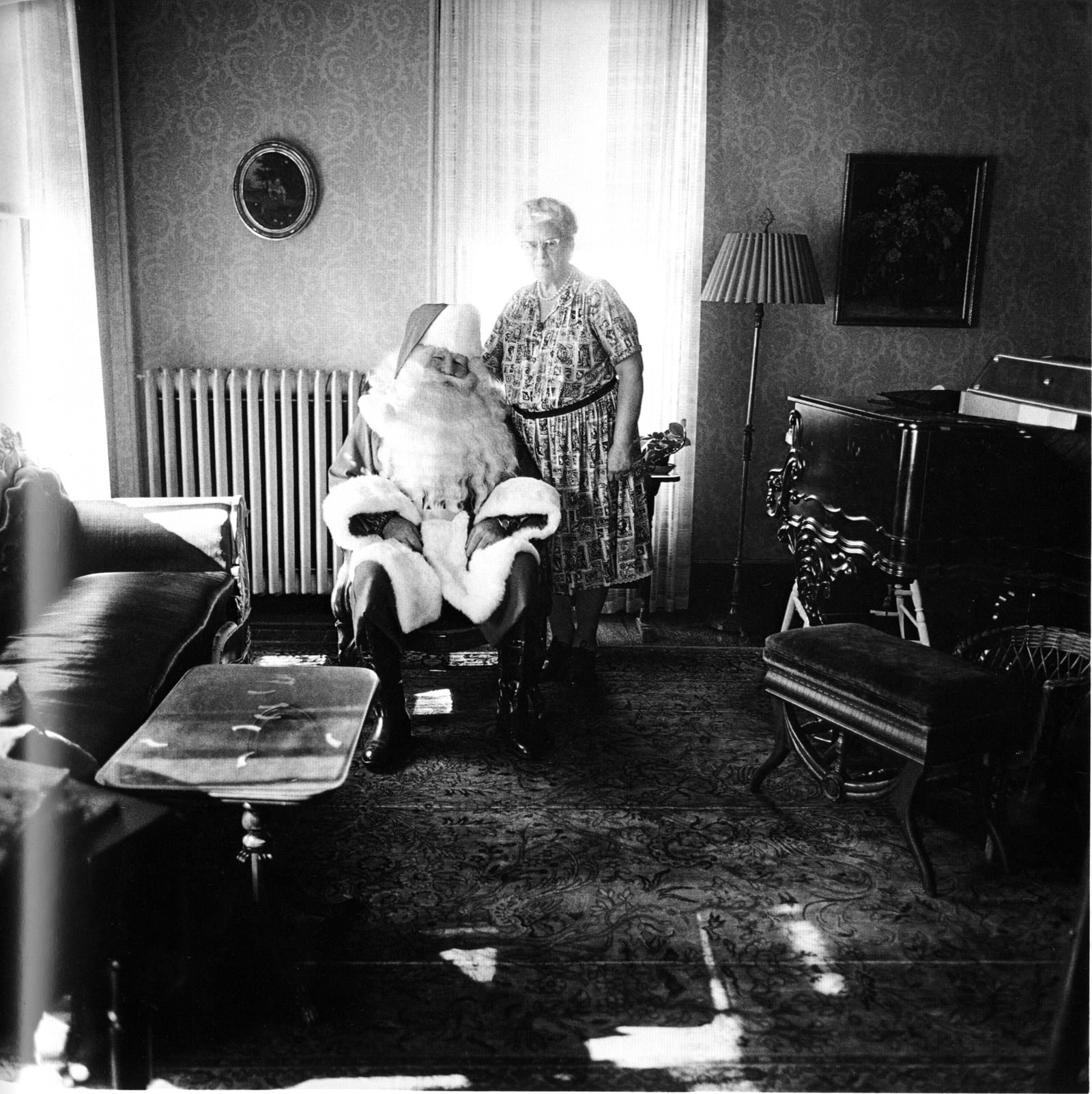 Diane Arbus (1923-1971): Mr. and Mrs. Santa Claus in their living room, Albion, N.Y., 1964 (1 of 2)
