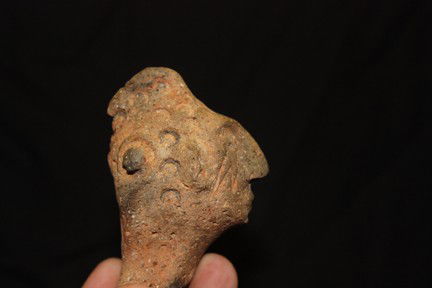 Rattle Head rim Effigy: This rattle head is most likely from a bowl that was broken off and them kept and used as a ceremonial item. It has ornate hair designs and weeping eye motif. Found in Missouri. 3 ½" x 2" D