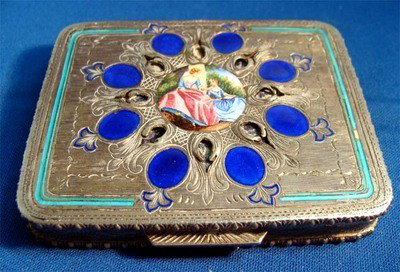 Enamel Silver Compact Blue Inlays Two Ladies: Unusual silver enamel compact, the small painting of two women under a tree is framed by elaborate etched and engraved silver and brilliant large carnelian blue accents surrounding. Inside is the orig