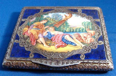 Enamel .800 Silver Compact Semi-Nude Woman With Man And: Lovely square enamel and silver compact, painting of a semi-nude woman resting next to a man and several sheep, a stream is in the background. The painting is framed with silver engraving and carnelia