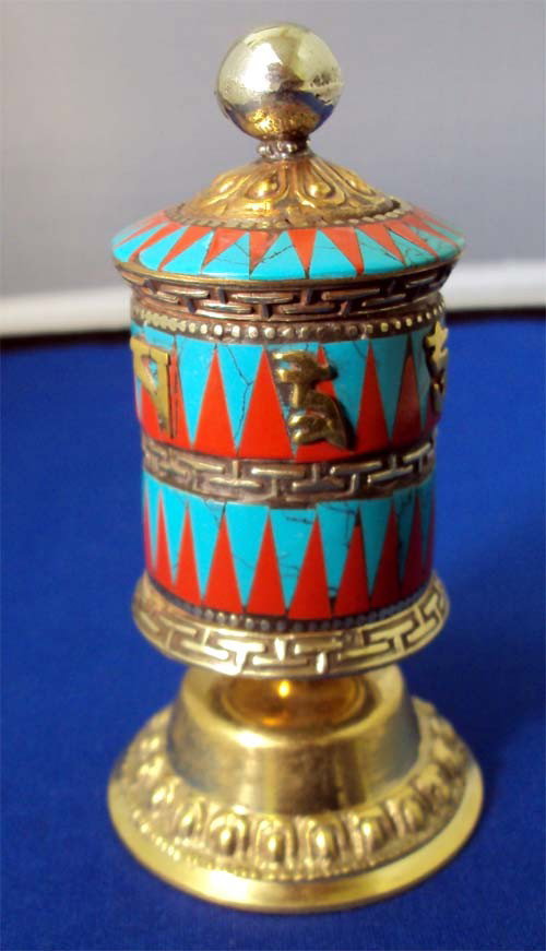 Tibetan Buddhist Table Prayer Wheel Turquoise & Coral: A prayer wheel is a holy object containing the Tibetan mantra "Om! Mane Padme Hum!" ("Hail! Jewel in the Lotus!") written many times on a scroll of paper rolled up inside. Dimensions 4.5" by 2.5"