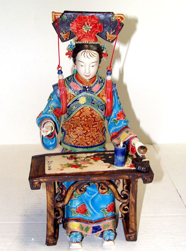 Porcelain Japanese Lady With Headdress Painting P: Seated at a table with paints and brushes, in a beautiful dress and hat. Detailed decoration, 13 inches tall,