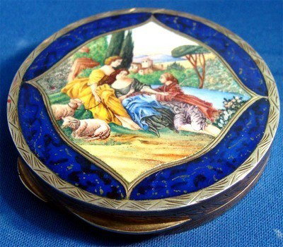 Round Enamel 800 Silver Compact Man With 2 Women: An elegant silver engraved compact depicts two woomen and a man in a park by a stream, with several sheep. Stamped 800 inside. The enamel painting is framed by silver engraving and carnelian blue enam