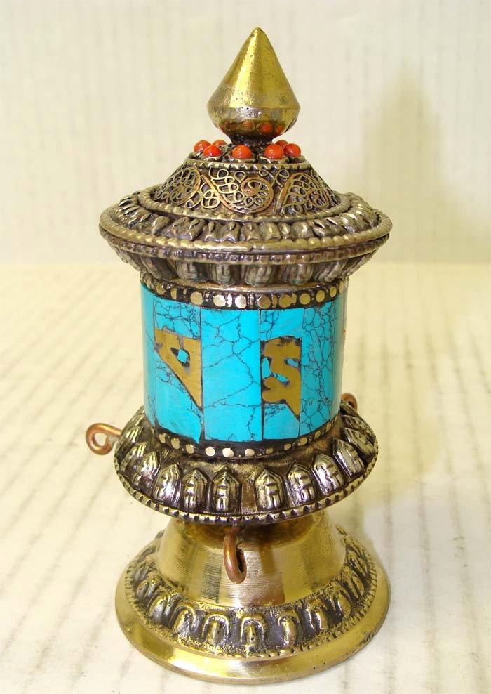 Tibetan Buddhist Table Prayer Wheel Turquoise & Coral: A prayer wheel is a holy object containing the Tibetan mantra "Om! Mane Padme Hum!" ("Hail! Jewel in the Lotus!") written many times on a scroll of paper rolled up inside. Dimensions 4.5" by 2.5"