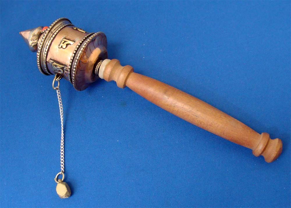 Nepalese Tibet Prayer Wheel Coral & Copper & Wood: Traditional Prayer wheel from Tibet, the rotating head is close to 2 1/2" in length and the total length is 8". A brass weight is attached to the side by a chain, and it is this weight, combined with 