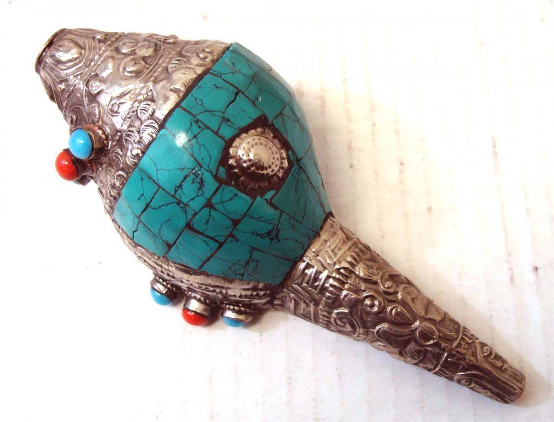 Nepalese Turquoise Coral Silver Sacred Conch: This beautiful Ritual Conch Shell is intricately carved with silver and semi precious stones, turquoise and coral. Wonderful workmanship! Dimensions 6" long by 2.5" wide.